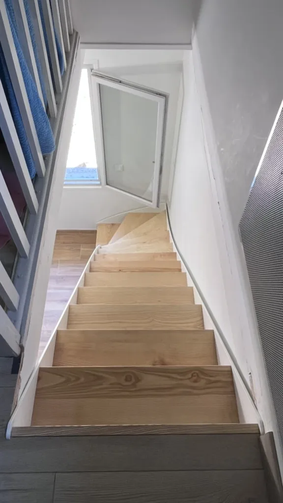 Escalier bois métal quart-tournant thermolaqué blanc avec marches Frêne massif huilé.